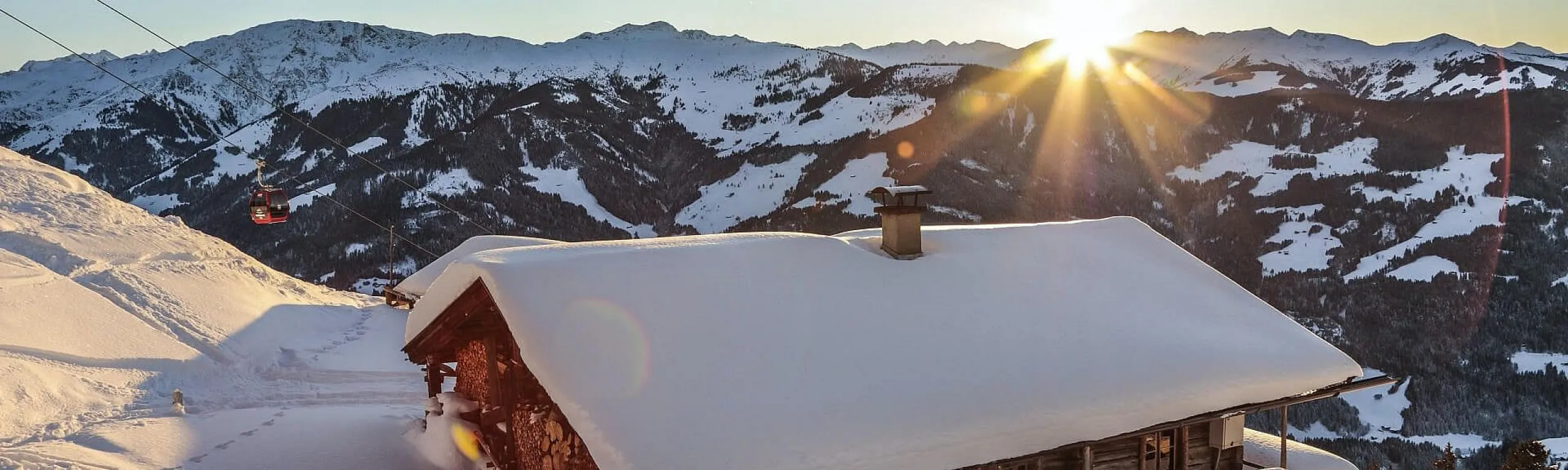 Sonnenaufgang über einer Schneelandschaft mit Hütte