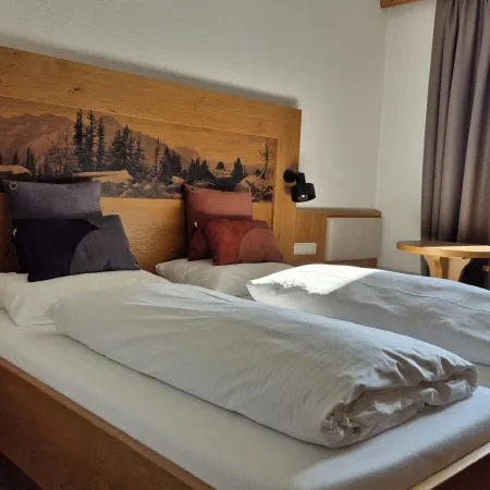 Helles Doppelzimmer mit Holzdekor und Aussicht auf die Berge