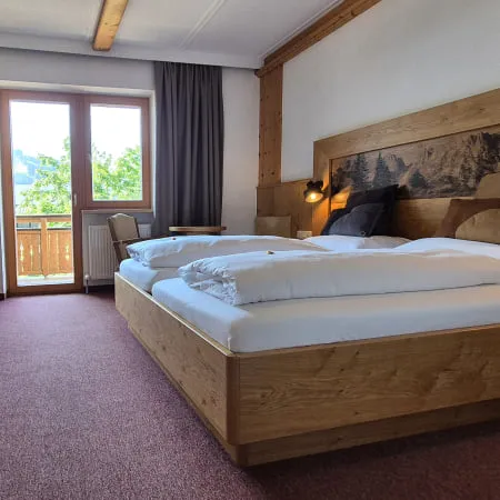Gemütliches Hotelzimmer mit Doppelbett und Balkonzugang