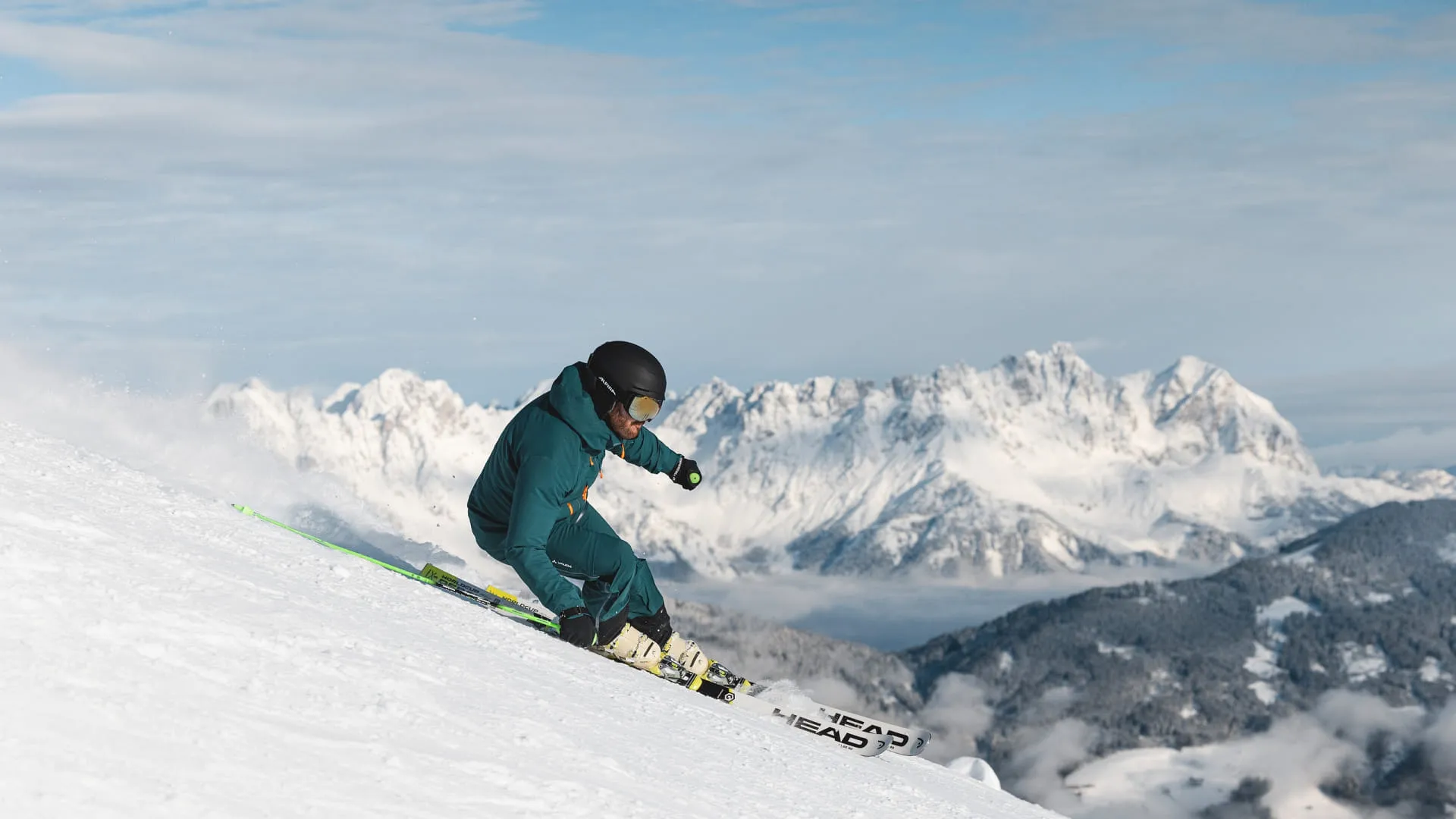 Skifahrer auf einer Piste mit Bergen im Hintergrund