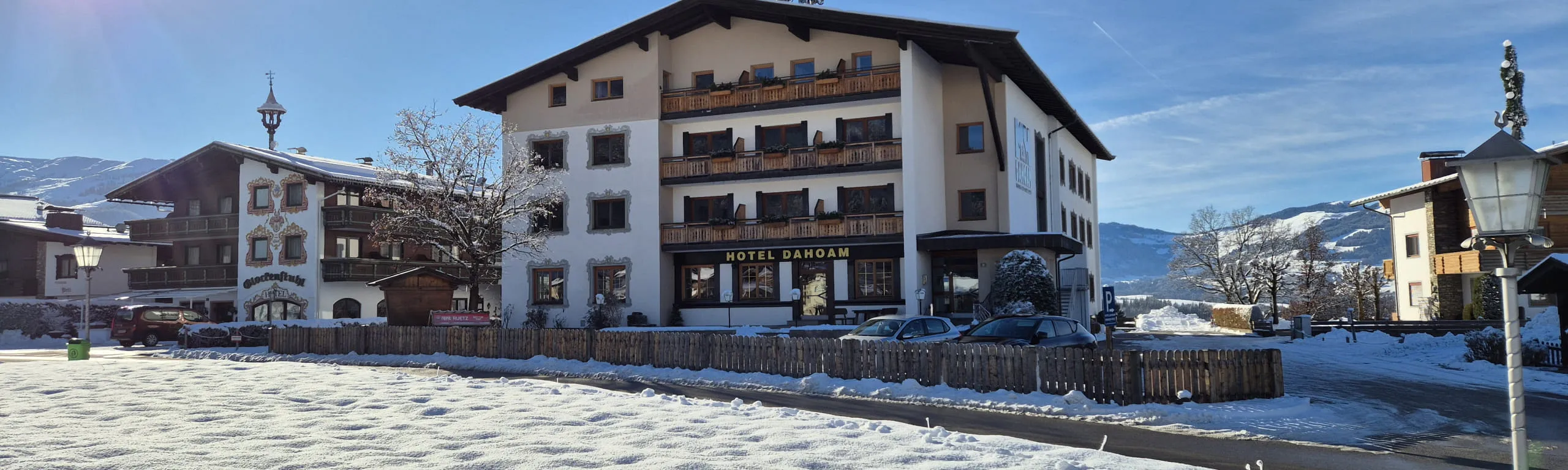 Winterliche Ansicht eines Hauses mit Schnee und umliegenden Gebäuden.