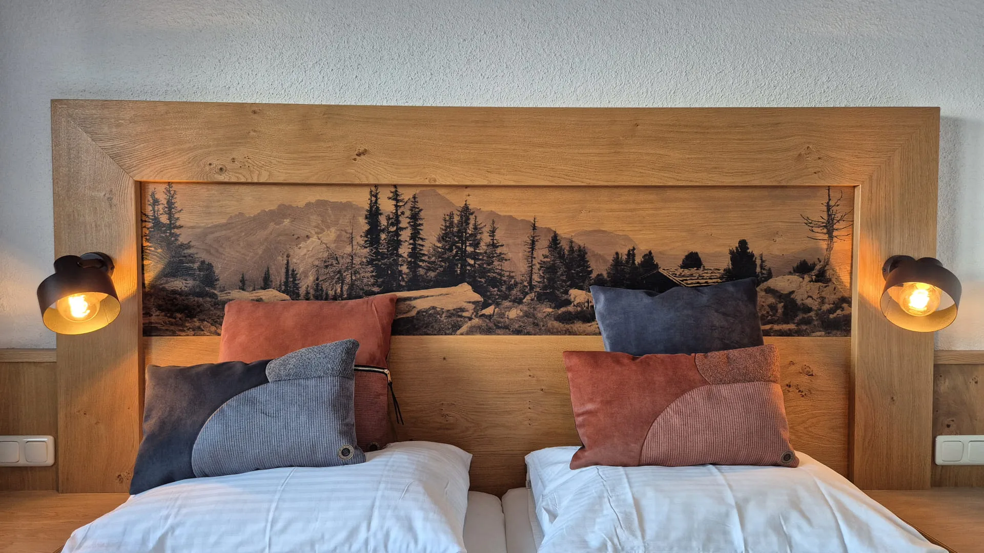 Holzheadboard mit Landschaftsmotiv und Kissen in orange und blau