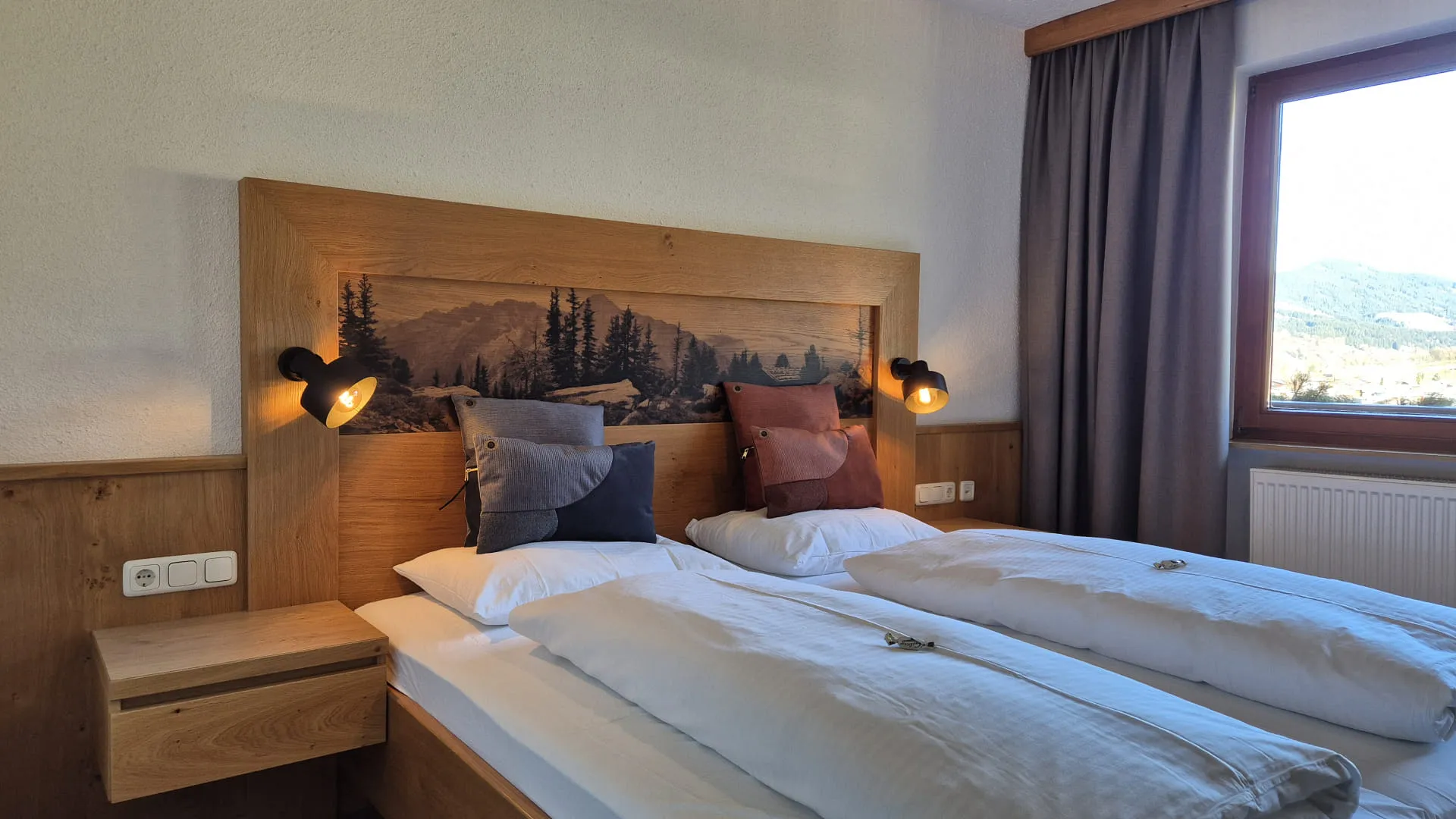Ein komfortabler Schlafbereich mit zwei Betten und Holzdetails.
