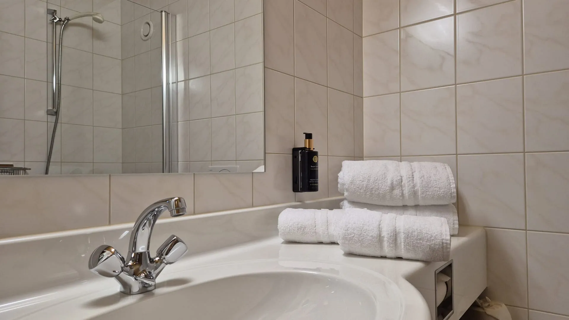Helle Badezimmer mit Badewanne, Handtüchern und Spiegel.